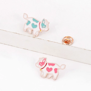 Detailed close-up of blue and pink enamel flying cow pins with rose gold metal edges
