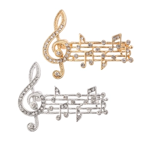 Elegant musical note brooches in gold and silver set with sparkling white crystals