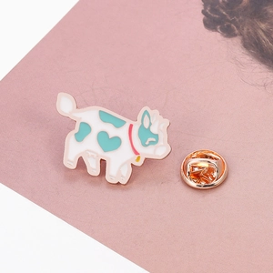 Detail of cartoon flying cow enamel pin with heart-shaped spots and rose gold plating