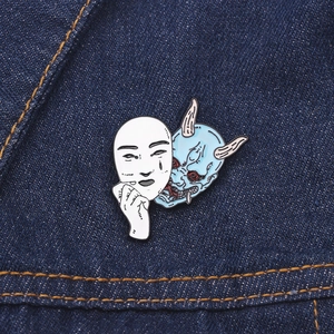 Detail of dual-style Oni Hannya enamel pin showing intricate metal craft on denim fabric
