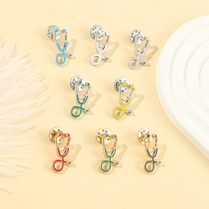 Lot de 8 broches stéthoscope colorées en émail pour médecins et infirmières sur fond beige
