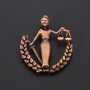 Vintage bronze Libra brooch featuring Lady Justice with scale and sword on black background