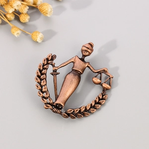 Macro shot of retro bronze Libra badge with Justice Goddess and laurel wreath