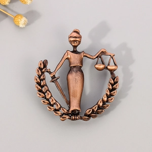 Macro view of Libra justice goddess pin with bronze finish and balanced scale details