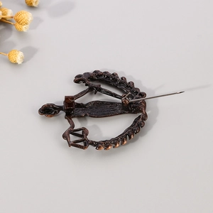 Detail view of the vintage bronze Libra brooch back with a secure rotating safety pin lock