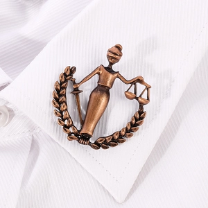 Antique bronze Libra Lady Justice brooch on a white striped shirt collar