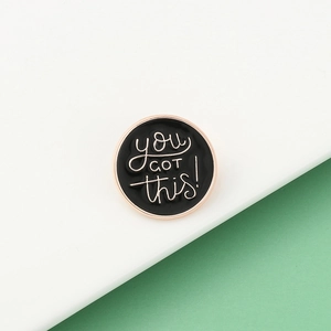Macro della spilla circolare in smalto nero con scritte You Got This oro rosa