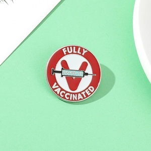 Macro detail of red and white COVID-19 Fully Vaccinated badge with syringe design