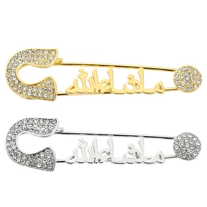 Detail of silver and gold plated Arabic Mashallah brooches with sparkling crystals