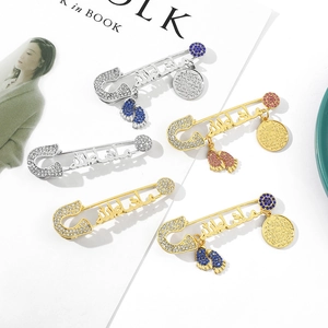 Detail of rhinestone foot pendant brooches in gold and silver with Arabic calligraphy