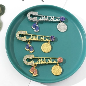 Detailed view of Mashallah Muslim pins with crystal footprints and embossed coins