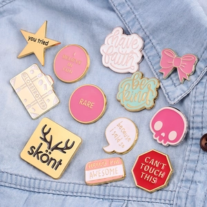 Variety of colorful creative enamel pins with letter designs on denim fabric