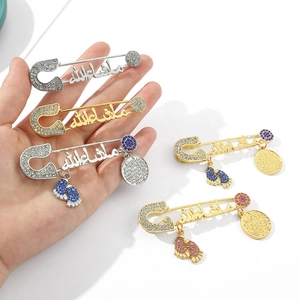 Macro shot of Islamic safety pin brooch with crystals and Arabic Mashallah calligraphy