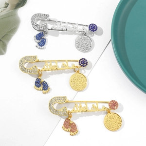 Detail of baby safety brooches with Arabic Mashallah script and sparkling rhinestones