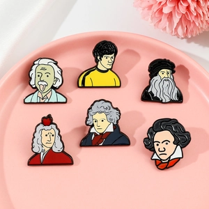 Detail shot of creative celebrity enamel pins featuring Einstein and Newton in a ceramic tray
