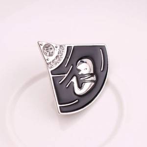 Detail van de emaille baby foetus broche met zwarte achtergrond en kristallen