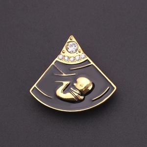 Detail van baby-echografie broche in zwart emaille en goud met witte zirkonia steen