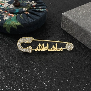 Close-up of gold Arabic Mashallah brooch with sparkling crystal rhinestones inlay
