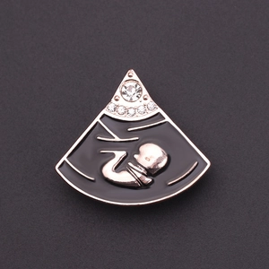 Detailopname van echofetusbroche met roségouden afwerking en witte kristallen