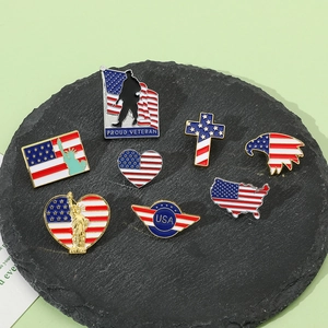 Vista piatta di spille patriottiche USA con motivi della bandiera e Statua della Libertà