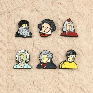 Close-up of six creative enamel pins featuring cartoon portraits of famous historical figures