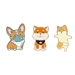 Detailed macro view of three distinct enamel dog pins featuring Corgi and Shiba Inu designs