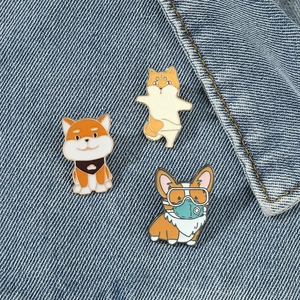 Detailed close-up of three cute enamel cartoon dog pins on a blue denim jacket background