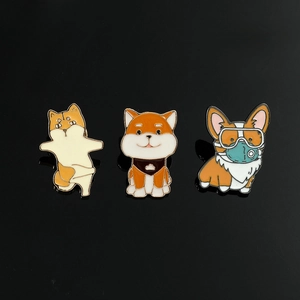 Detailed view of three cute enamel shiba inu and corgi metal badges on black background