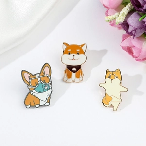 Detailed view of three cute cartoon puppy enamel pins on white silk with floral accents