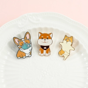 Detailed view of three cute cartoon dog enamel pins featuring Corgi and Shiba Inu designs