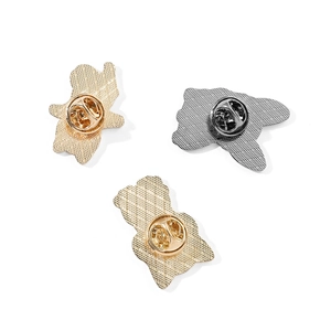 Detail view of metal butterfly clutch backings and mesh texture on enamel dog pins