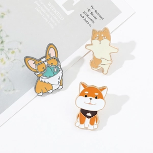Detailed macro shot of three cute enamel dog pins featuring Corgi and Shiba Inu designs