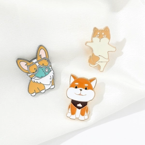 Detailed view of three cartoon dog enamel pins on a white silk fabric background