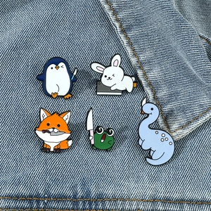 Set van vijf cartoon dierenpins van emaille met kleine messen op blauwe denim