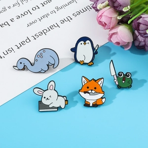 Detailopname van schattige emaille speldjes met grappige cartoon dieren en kleine messen