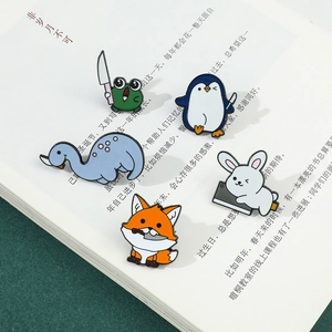 Detailopname van vijf grappige dieren emaille pins met messen op een open boek