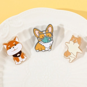 Three cute cartoon dog enamel pins featuring Shiba Inu and Corgi on a white plate