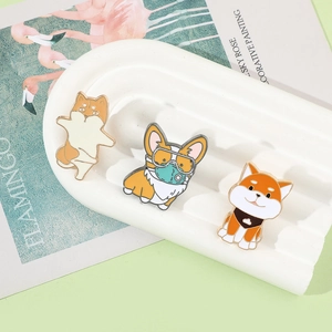 Detailed view of three cartoon dog enamel pins featuring Corgi and Shiba Inu designs