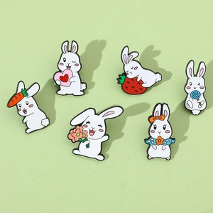 Detailansicht von bunten Emaille-Pins mit süßen Hasen, die Karotten und Blumen halten