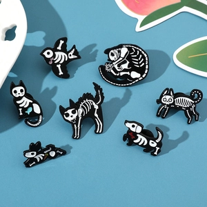 Close-up of enamel skeleton animal pins featuring cats and dogs on a blue backdrop