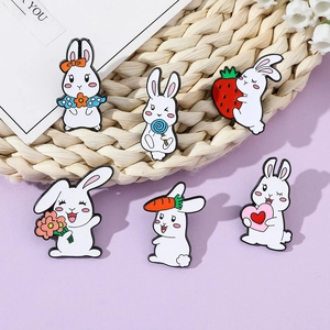 Detail von sechs Cartoon-Hasen-Emaille-Pins mit Blumen- und Erdbeermotiven auf lila Grund