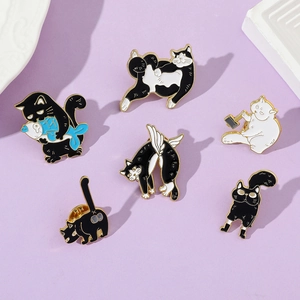 Detailed close-up of six creative cartoon cat enamel pins on a soft purple background