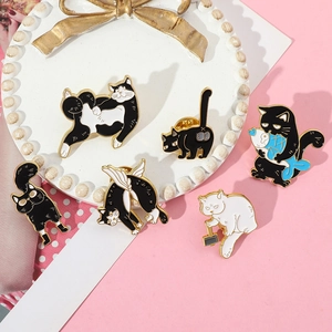 Detailed macro shot of six cute cartoon cat enamel pins on a white beaded jewelry tray