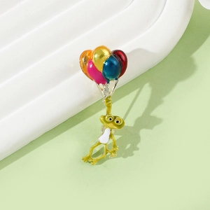 Gros plan détaillé d'une broche en émail représentant un grenouille avec ballons colorés