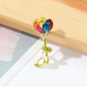 Détail d'une broche grenouille mignonne avec des ballons colorés en émail poli