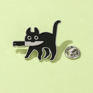 Gros plan sur le pin's émaillé chat noir avec couteau et fermoir papillon argenté