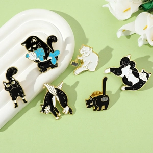 Detailed view of six cute cartoon cat enamel pins in black and white with gold finish