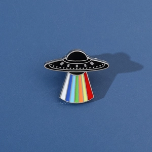 Detail of UFO enamel pin with colorful rainbow beam and polished silver metallic edges