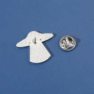 Silver metal astronaut pin back showing textured surface and butterfly clutch fastener