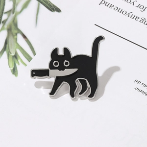 Détail du pin's émaillé chat noir avec couteau sur carte blanche avec des plantes